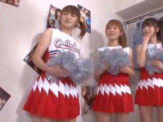 Kolme iso tiainen japanilainen cheerleaderit jakaminen pistellä